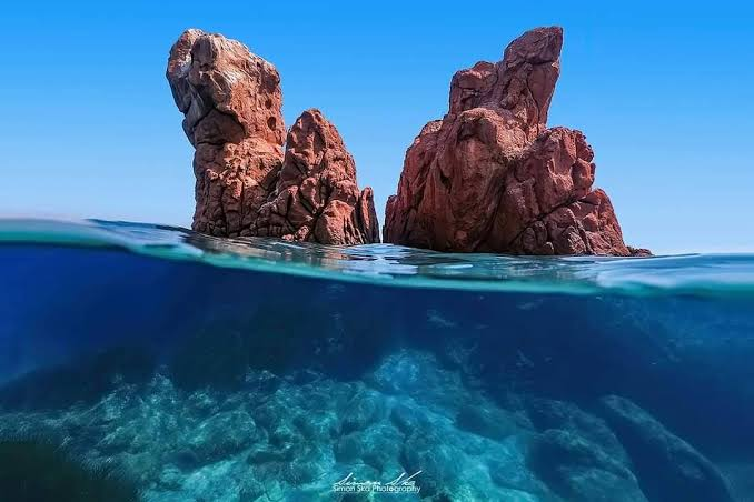I faraglioni rossi della spiaggia di Cea tra mare e cielo